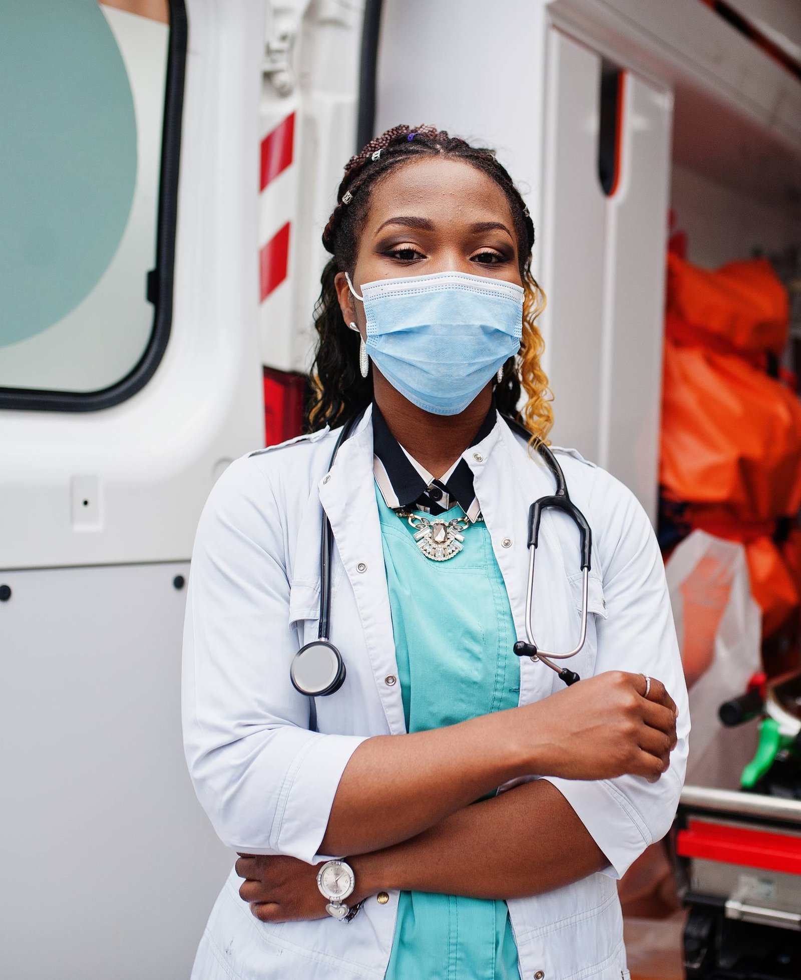 A paramedic standing at the open rear doors of an ambulance