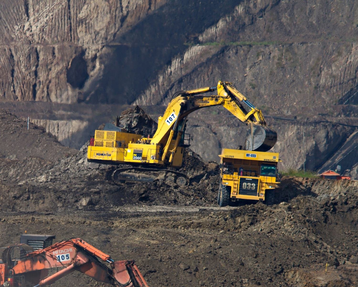 Excavators loading haul trucks in an open-pit mine